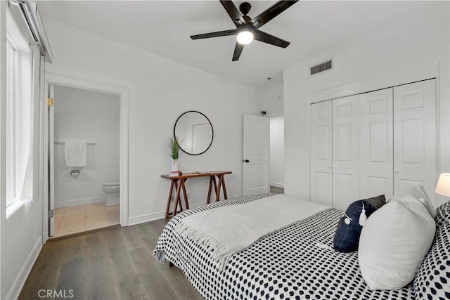 bedroom featuring ceiling fan, a closet, connected bathroom, and dark hardwood / wood-style flooring