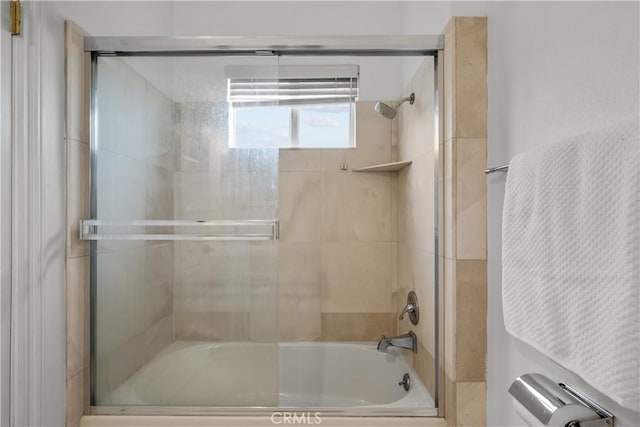 bathroom with shower / bath combination with glass door