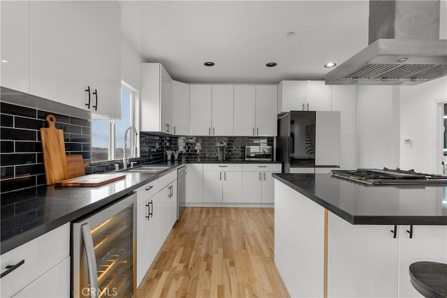 kitchen with beverage cooler, white cabinetry, and island exhaust hood