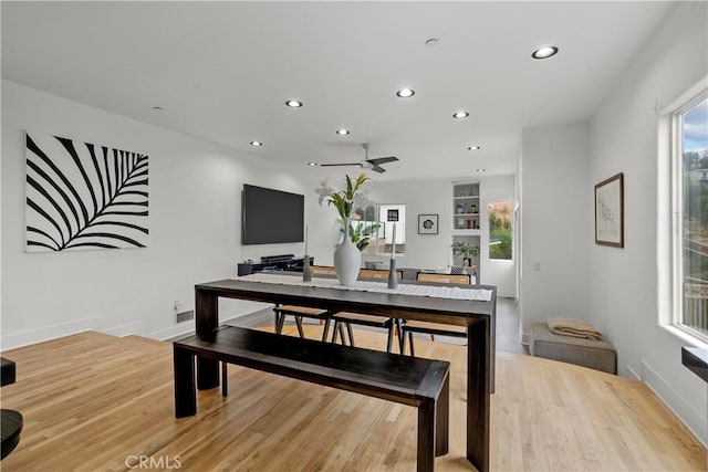 dining area featuring ceiling fan, built in shelves, and light wood-type flooring