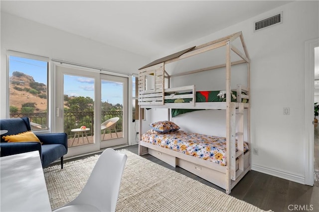 bedroom with vaulted ceiling, dark hardwood / wood-style flooring, and access to outside