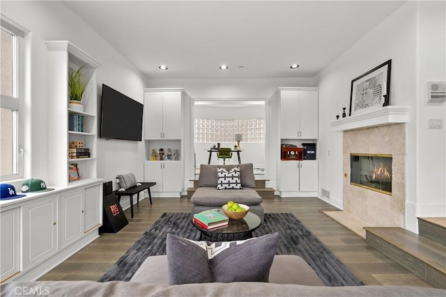 living room featuring dark wood-type flooring and a tiled fireplace