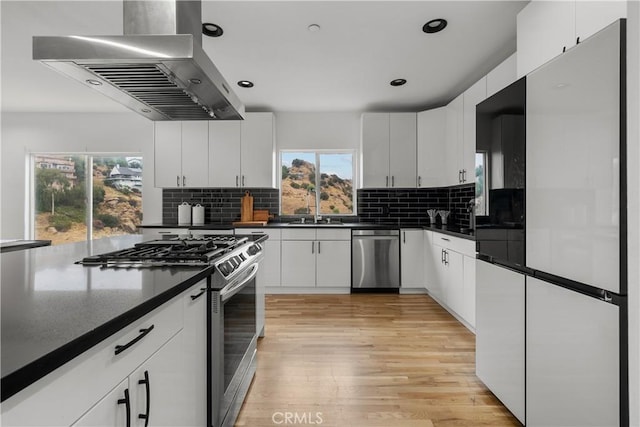 8350 Hillcroft Dr, West Hills, CA 91304 - kitchen with appliances with stainless steel finishes, range hood, dark countertops, a sink, and light wood-type flooring
