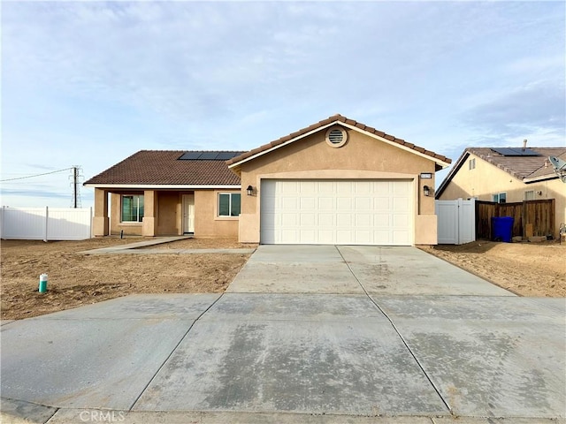 ranch-style house with a garage and solar panels