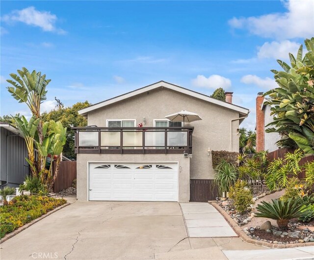 front of property featuring a balcony and a garage