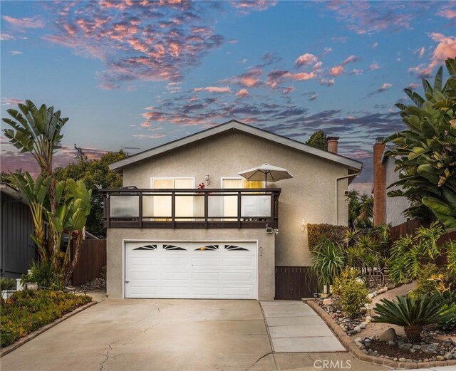 view of front of property featuring a garage and a balcony