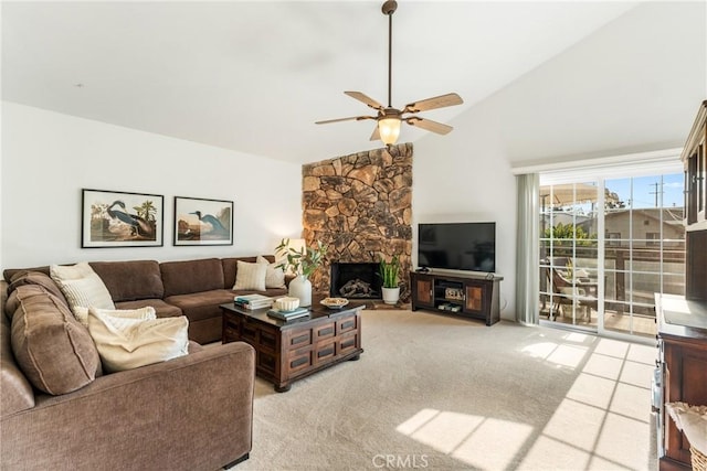 living room with ceiling fan, light colored carpet, a stone fireplace, and high vaulted ceiling