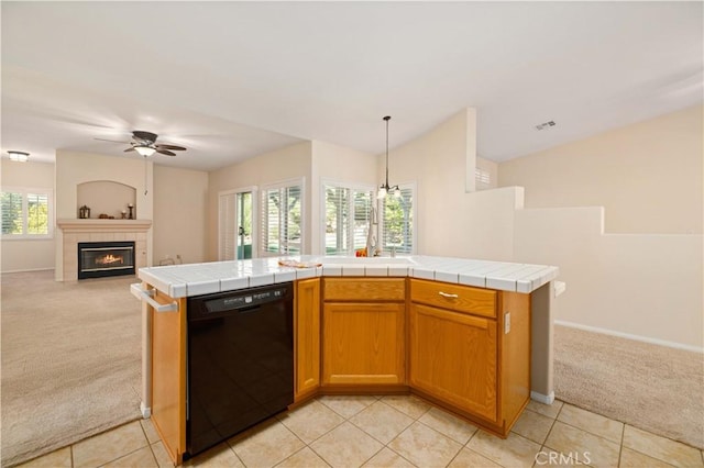 kitchen with tile counters, black dishwasher, and a wealth of natural light