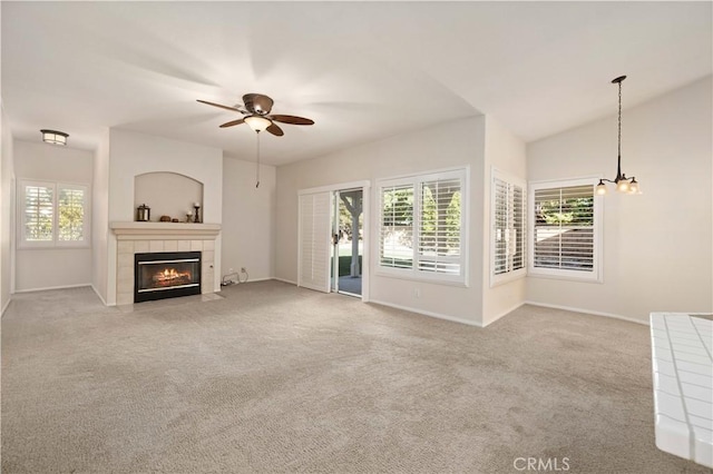 unfurnished living room featuring a tile fireplace, light carpet, ceiling fan, and lofted ceiling