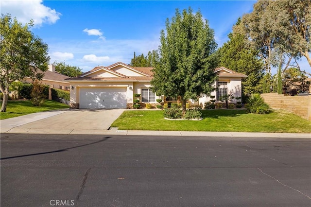 view of front of house featuring a garage, concrete driveway, a tiled roof, a front yard, and stucco siding