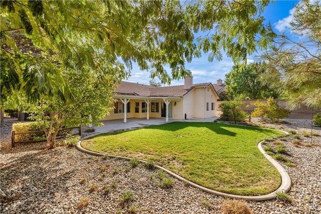 back of house featuring a patio area and a yard