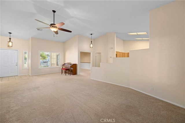 unfurnished living room with light colored carpet, high vaulted ceiling, and ceiling fan