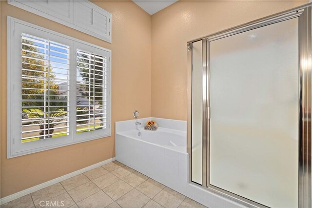 bathroom with tile patterned flooring, separate shower and tub, and a wealth of natural light