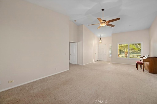 carpeted empty room with ceiling fan and high vaulted ceiling