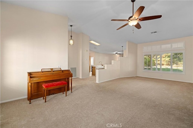 interior space featuring light carpet, vaulted ceiling, and ceiling fan