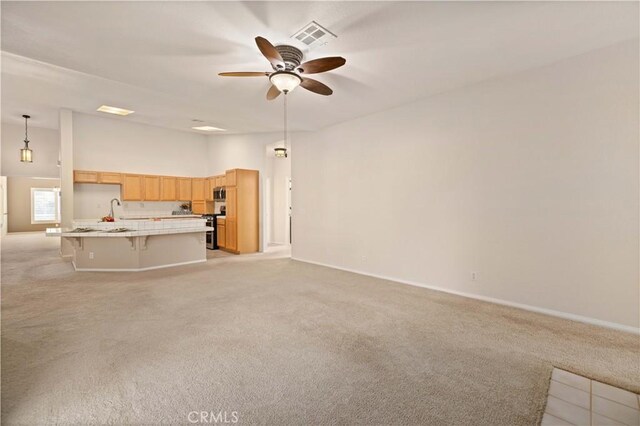 unfurnished living room with ceiling fan and light colored carpet