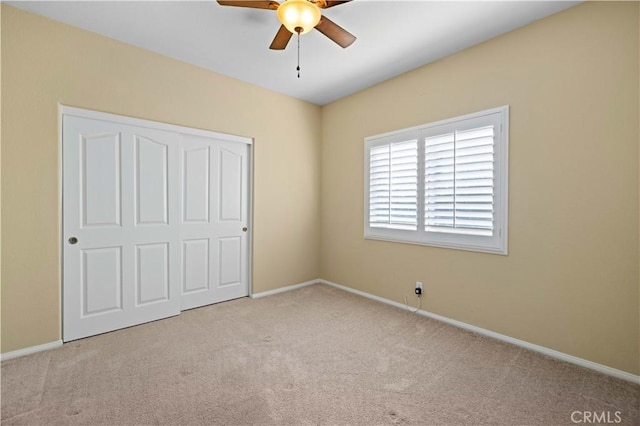 unfurnished bedroom with a closet, light colored carpet, and ceiling fan