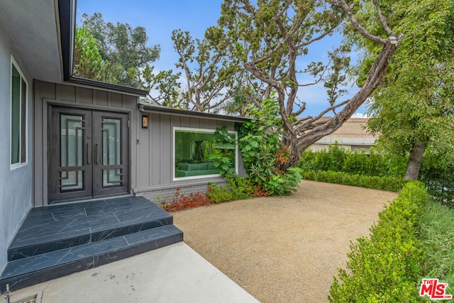 view of exterior entry featuring french doors and a patio