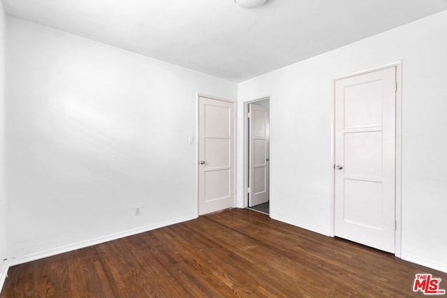 unfurnished bedroom featuring dark hardwood / wood-style flooring