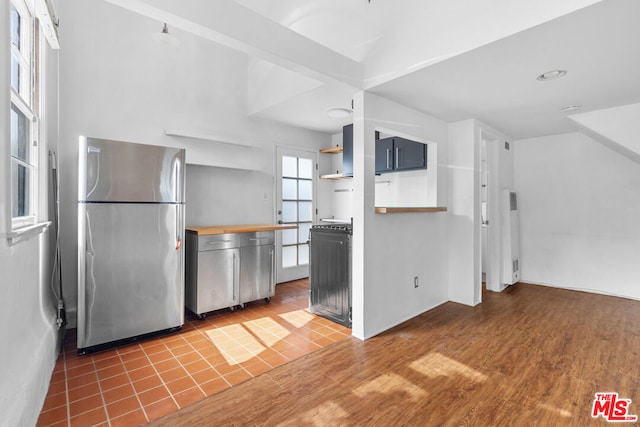 kitchen featuring hardwood / wood-style flooring and stainless steel fridge