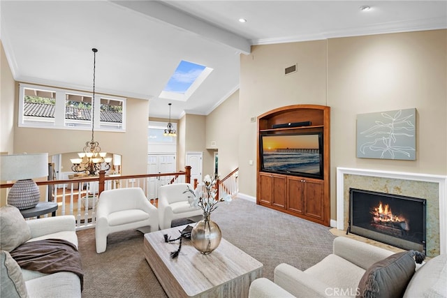 living room featuring an inviting chandelier, carpet, a high end fireplace, crown molding, and beamed ceiling