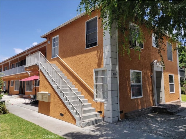2219 Pine Ave, Long Beach, CA 90806 - rear view of property featuring stairway, stucco siding, and a patio