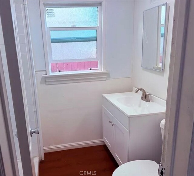 2219 Pine Ave, Long Beach, CA 90806 - bathroom featuring vanity, toilet, wood finished floors, and baseboards
