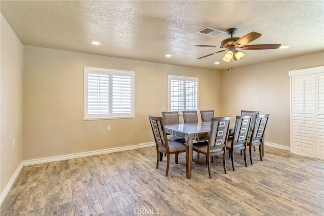 dining space featuring hardwood / wood-style floors, a textured ceiling, and ceiling fan