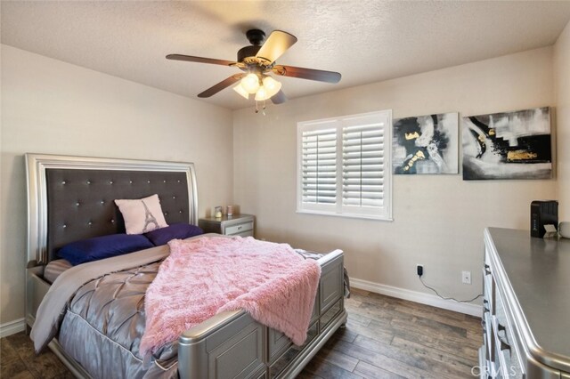 bedroom with dark wood-type flooring, a textured ceiling, and ceiling fan