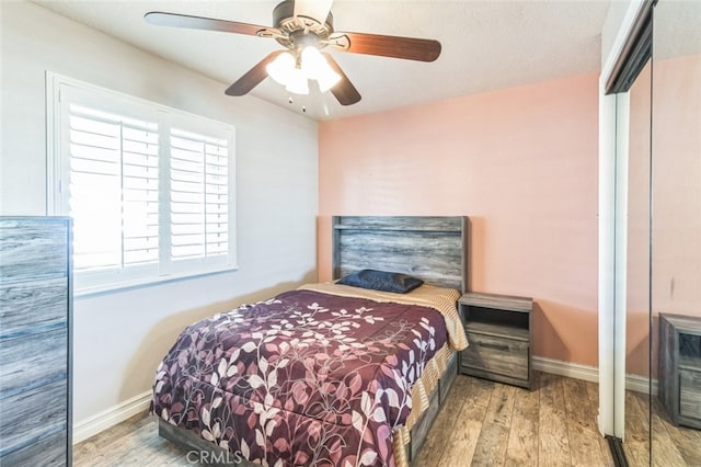 bedroom with wood-type flooring and ceiling fan