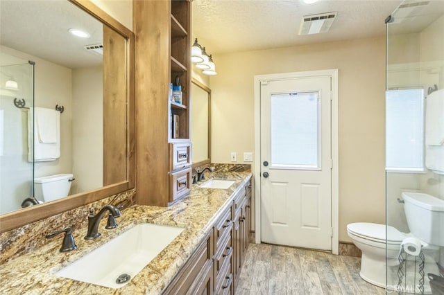 bathroom featuring toilet, a textured ceiling, hardwood / wood-style flooring, and vanity