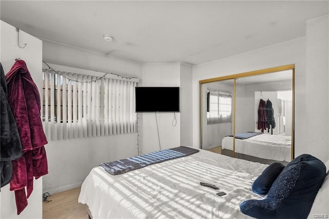 bedroom with light hardwood / wood-style flooring and a closet