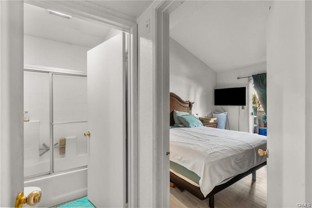 bedroom featuring light wood-type flooring and vaulted ceiling