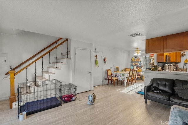 living room featuring light hardwood / wood-style floors and a textured ceiling