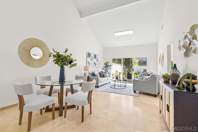 dining space featuring light tile patterned flooring and high vaulted ceiling