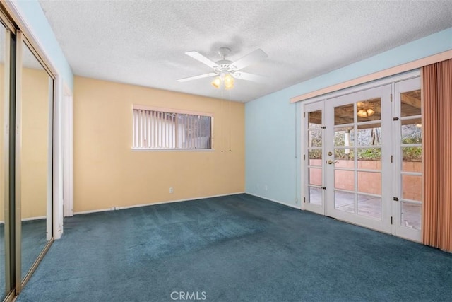 empty room with ceiling fan, french doors, dark carpet, and a textured ceiling