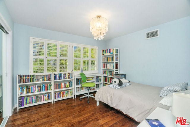 bedroom featuring dark wood-type flooring and a chandelier