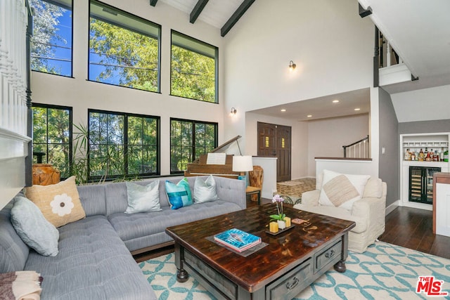 living room with hardwood / wood-style floors, beamed ceiling, wine cooler, high vaulted ceiling, and built in shelves