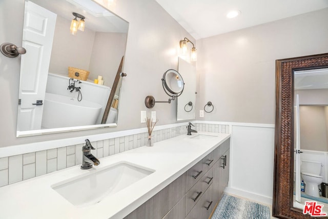 bathroom featuring a bathtub, vanity, and toilet