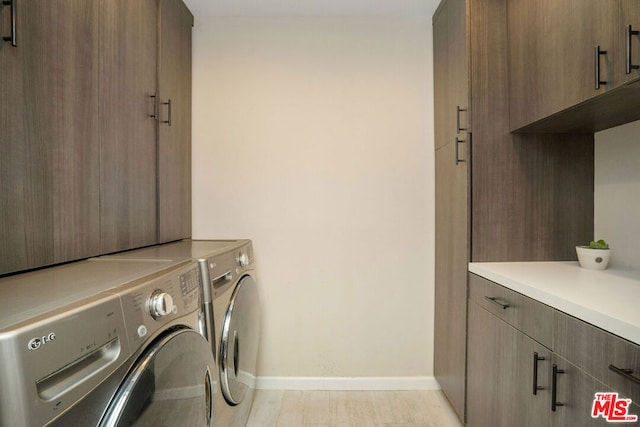 laundry area featuring cabinets and washing machine and clothes dryer