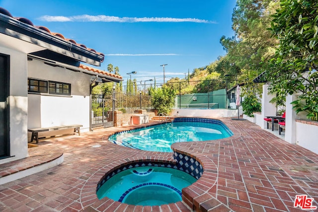 view of swimming pool with an in ground hot tub and a patio area