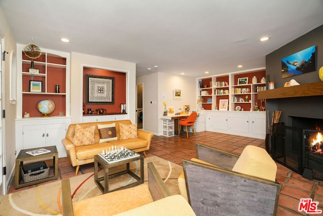 living room featuring built in features, washer / dryer, and tile patterned flooring