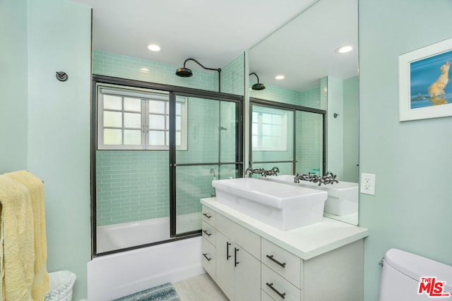 full bathroom with shower / bath combination with glass door, vanity, and toilet