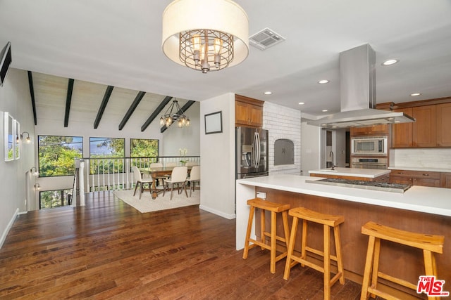 kitchen with island exhaust hood, appliances with stainless steel finishes, dark wood-type flooring, a chandelier, and lofted ceiling with beams