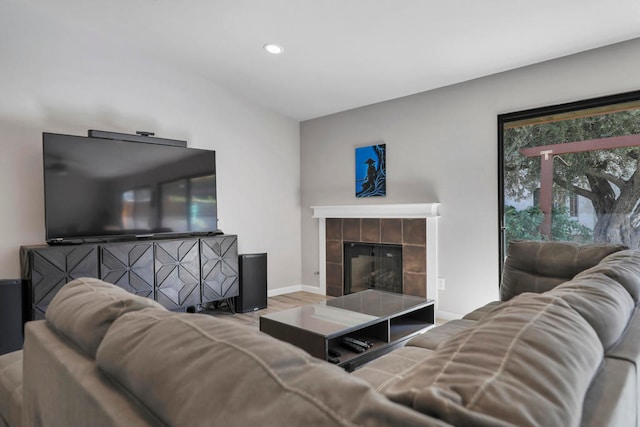 living room with wood-type flooring and a tile fireplace