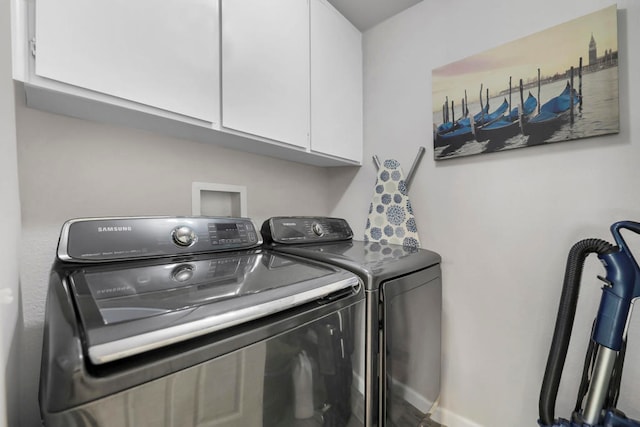 laundry area with washer and dryer and cabinets