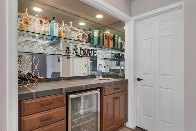 bar with hardwood / wood-style floors, sink, and beverage cooler