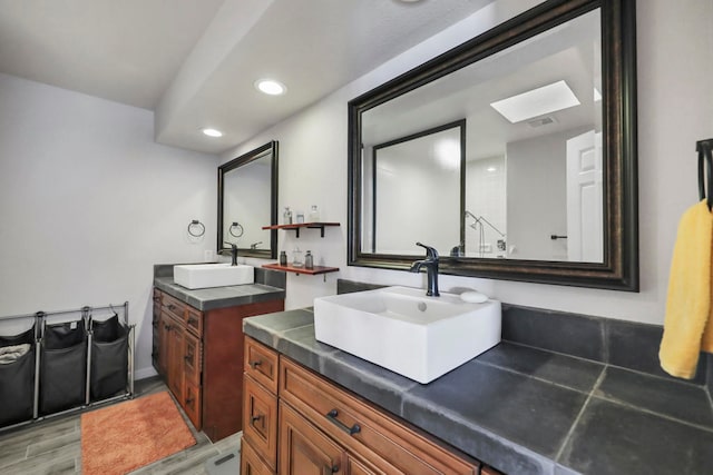 bathroom featuring vanity, a skylight, and hardwood / wood-style floors