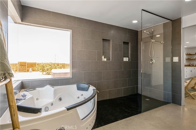 bathroom with shower with separate bathtub and tile walls