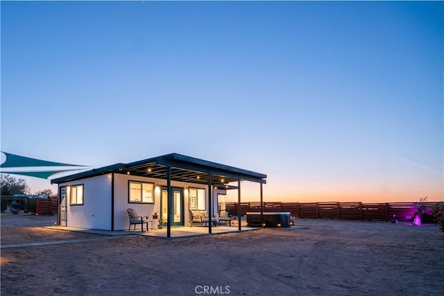 back house at dusk with a patio